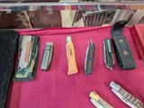 many different types of knives on a pink cloth