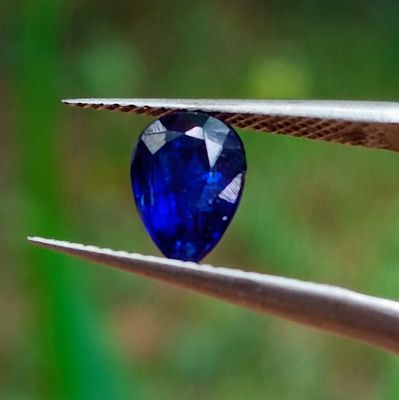 un gros plan sur une pince tenant un diamant bleu