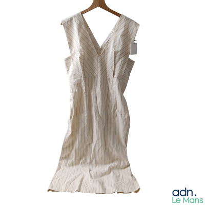 a white dress hanging on a hanger on a white wall