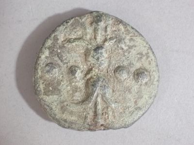 a coin with a face on it on a white surface