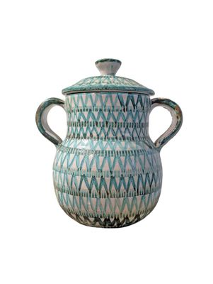 a blue and white vase with a lid on a white background