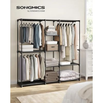 a black metal shelving with clothes hanging on it in front of a white wall