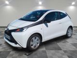 une Toyota AY blanche garée dans une pièce au sol carrelé