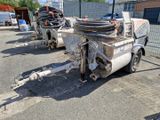 un camion garé sur un parking, avec un tuyau fixé à l'arrière