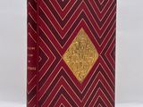a red and gold book with a gold design on the cover