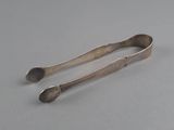 a pair of spoons sitting on top of a table next to each other
