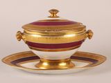 un bol et une soucoupe dorés et rouges, posés sur une soucoupe