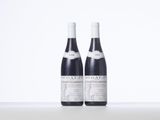 two bottles of wine sitting on top of a white table