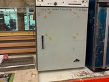 un réfrigérateur blanc posé sur une étagère dans un magasin