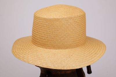 un gros plan d'un chapeau de paille sur une tête de mannequin