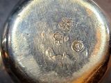 a close up of a silver pocket watch on a table
