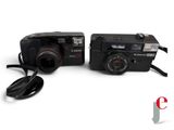 two cameras sitting next to each other on a white surface
