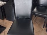 a lot of black leather chairs in a restaurant