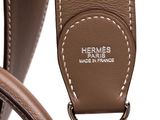 the handle of a brown leather bag with a metal clasp