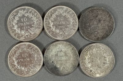 six types différents de pièces d'argent posées sur une surface grise