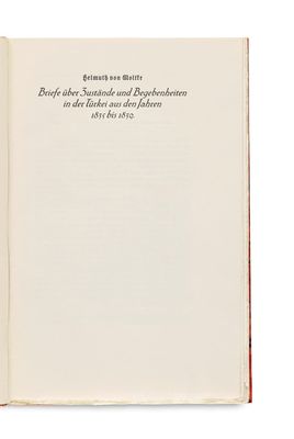 an open book on a white surface with a red border