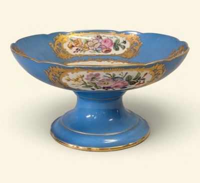 un bol bleu orné d'une bordure dorée et de motifs floraux