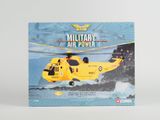 hélicoptère militaire miniature dans sa boîte, posé sur une surface blanche