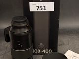 un objectif d'appareil photo et une tasse posés sur la table