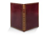 un vieux livre à la couverture rouge posé sur une surface blanche