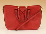 a red purse with gold handles and a strap