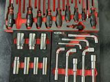 les nombreux outils qui se trouvent dans le bac posé sur la table