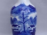 a blue and white vase sitting on a white surface