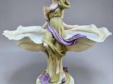 figurine représentant une femme tenant une fleur à la main