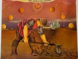 la pochette d'un album représentant un homme avec une pelle dans le désert