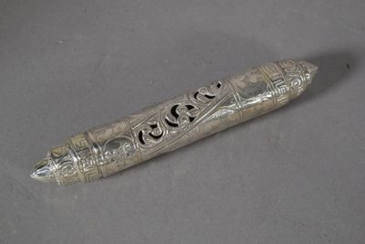 un vieux stylo en argent posé sur une table, à côté d'une feuille de papier