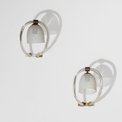 une paire de boucles d'oreilles en argent et en or posées sur une surface blanche