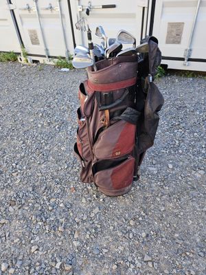 un sac de clubs de golf posé par terre à côté d'un conteneur