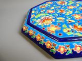 une petite boîte bleue décorée de fleurs, posée sur une table