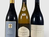 trois bouteilles de vin posées les unes à côté des autres sur une surface blanche