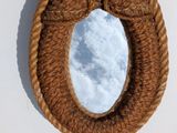 a mirror hanging on the wall with a rope around it