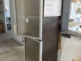 a refrigerator in the middle of a kitchen that is being remodeled