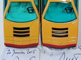 two yellow and green toy cars on display in a display case