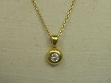 a yellow gold necklace with a diamond on a mannequin