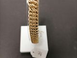 a close up of a gold bracelet on a stand on a table
