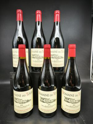 six bouteilles de vin sont alignées sur un comptoir