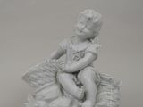 a white statue of a child sitting on a basket