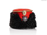 un chapeau rouge orné d'un insigne doré