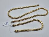 two gold plated necklaces on a white background with a price tag