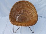 a wicker chair on a metal stand on a white background