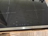 a black stove top with a glass top on a wooden table
