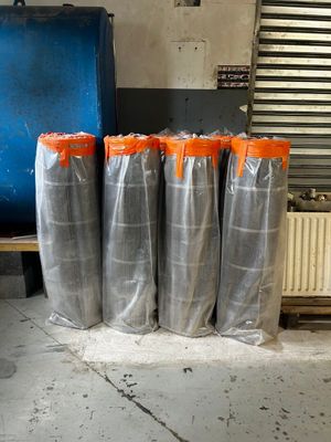 four bags of silver and orange plastic sitting on a bench
