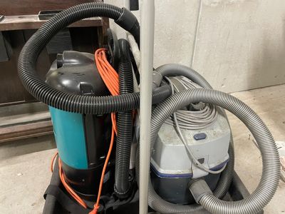 un aspirateur posé par terre à côté d'un poteau