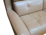 beige leather sofa with rounded arms and back cushions