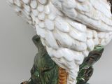a white bird that is standing on a green base