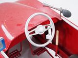 a red toy car with a steering wheel and dashboard